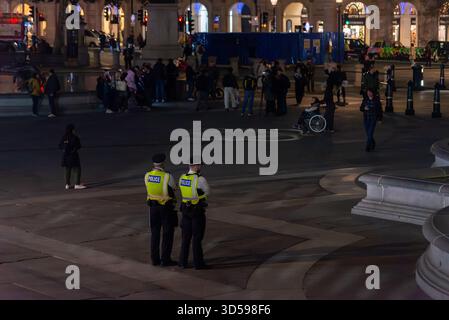 La polizia pattuglia Trafalgar Square in preparazione per una protesta anti-governativa Million Mask March di notte. Le persone cominciano a riunirsi Foto Stock