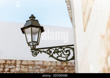 Vista ravvicinata di una lanterna decorativa a Faro, Algarve, Portogallo. L'immagine mette in risalto il design intricato e il fascino storico della stre di Faro Foto Stock