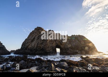 Onde che si infrangono contro la formazione rocciosa Keyhole Arch a Pfeiffer Beach, Big Sur, California. Foto Stock