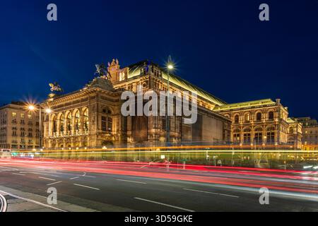 Vista notturna del Teatro dell'Opera di Vienna in Austria, catturata il 1° novembre 2025, con architettura illuminata e percorsi luminosi dinamici Foto Stock