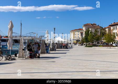 Porec, Croazia, Istria - 25 settembre 2023: Lungomare in via Marshal Tito, porto per navi e traghetti passeggeri. Pittoresca passeggiata sul mare Foto Stock