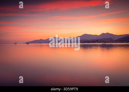 Calmo tramonto sulle acque calme con Mountain Horizon e barche a vela a Dusk, Corsica, Francia Foto Stock