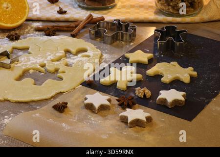 Impasto natalizio per biscotti, spezie e fornelli su un tavolo da cucina. Foto Stock