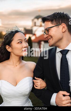 Coppia interrazziale che celebra il giorno del matrimonio guardarsi l'un l'altro Foto Stock