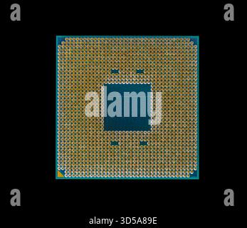 Primo piano di un processore per computer con pin placcati oro isolati su uno sfondo nero Foto Stock