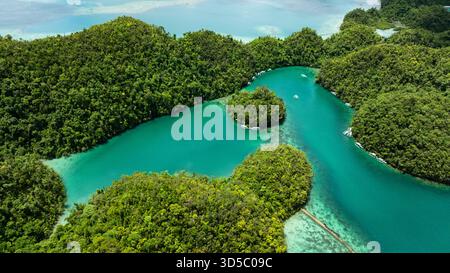 Vista aerea della laguna con piccole isole forestali e barche che galleggiano su acque calme. Siargao, Filippine. Laguna blu di Sugba. Foto Stock