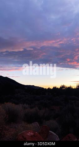 Il caldo tramonto dello Utah illumina un tranquillo paesaggio desertico con montagne e arbusti al crepuscolo, sereno e calmo. Parco nazionale di Zion Foto Stock
