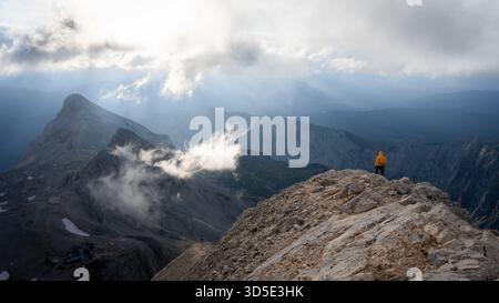 Escursionista in piedi sulla cima di una montagna godendo della vista sul bellissimo paesaggio alpino che precede, la Slovenia Foto Stock
