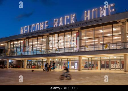 Tel Aviv, Israele. 15 novembre 2025. Civili israeliani visti davanti al Charles Bronfman Auditorium, che si trova accanto al Mann Auditorium, in Piazza Habima a Tel Aviv, Israele, mentre il grande cartello "Welcome Back Home" si illumina al tramonto di sabato 15 novembre 2025. Israele attende gli ultimi tre cadaveri che gli Hamas dovrebbero tornare per completare la prima fase del piano di pace sostenuto dagli Stati Uniti tra Israele e le forze di Hamas. La fase 2, quando avrà inizio, sarà cruciale, in quanto Hamas dovrebbe disarmarsi. Foto di Jim Hollander/UPI credito: UPI/Alamy Live News Foto Stock