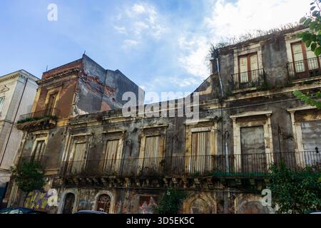 Edificio storico abbandonato con facciata sbriciolata e graffiti nella scena di Urban Street Foto Stock