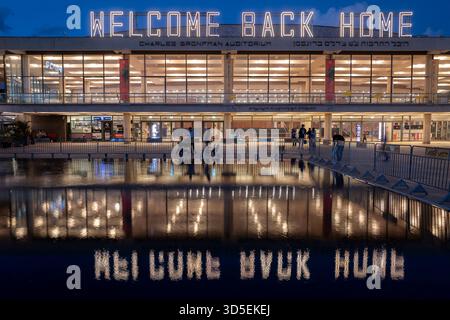 Tel Aviv, Israele. 15 novembre 2025. Civili israeliani visti davanti al Charles Bronfman Auditorium, che si trova accanto al Mann Auditorium, in Piazza Habima a Tel Aviv, Israele, mentre il grande cartello "Welcome Back Home" si illumina al tramonto di sabato 15 novembre 2025. Israele attende gli ultimi tre cadaveri che gli Hamas dovrebbero tornare per completare la prima fase del piano di pace sostenuto dagli Stati Uniti tra Israele e le forze di Hamas. La fase 2, quando avrà inizio, sarà cruciale, in quanto Hamas dovrebbe disarmarsi. Foto di Jim Hollander/UPI credito: UPI/Alamy Live News Foto Stock