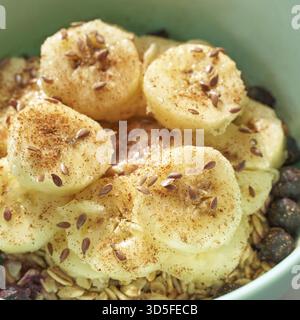 Colazione salutare. Vista dall'alto. Farina d'avena con semi di banana e lino nel recipiente. Frutti di bosco nel piatto. Ricetta biologica per i pasti. Cuoco vegano. Granola minimalista. Porr. Caldo Foto Stock