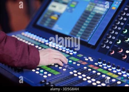 Sound ENGINEER controlla la console digitale di missaggio audio live. Messa a fuoco selettiva. Foto Stock