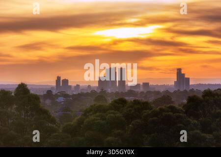 Alte torri commerciali di media distanza del CBD di Parramatta al tramonto, il suggestivo cielo arancione in Australia. Foto Stock