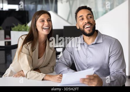 Colleghi felici e amici d'ufficio che lavorano su documenti cartacei Foto Stock