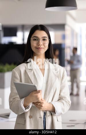 Felice di successo giovane donna asiatica professionale che tiene un tablet pc Foto Stock