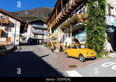 Belle e tradizionali case antiche del villaggio rango in provincia di Trento vicino al lago di Garda in Italia, vecchie case coloniche, auto d'epoca italiana parcheggiata Foto Stock