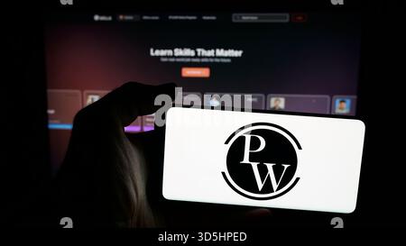 25 ottobre 2025, Germania: In questa foto, una persona ha in mano un telefono cellulare con il logo della società indiana Physics Wallah Limited (PW) sullo schermo davanti alla pagina web. (Immagine di credito: © Timon Schneider/SOPA Images via ZUMA Press Wire) SOLO PER USO EDITORIALE! Non per USO commerciale! Foto Stock