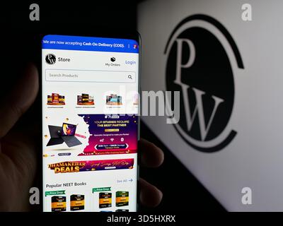 In questa illustrazione fotografica, una persona ha in mano un cellulare con la pagina web della società indiana Physics Wallah Limited (PW) sullo schermo davanti al logo. (Foto di Timon Schneider / SOPA Images/Sipa USA) *** esclusivamente per notizie editoriali *** Foto Stock