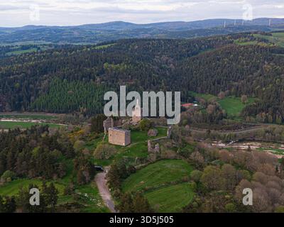 Vista aerea mozzafiato delle rovine dell'antico castello di Luc in mezzo a una pittoresca valle, che mostra la serena bellezza e il significato storico di t Foto Stock