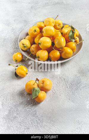 Mele piccole gialle, varietà cinese, su un piatto grigio, vista dall'alto, nessuna persona, Foto Stock