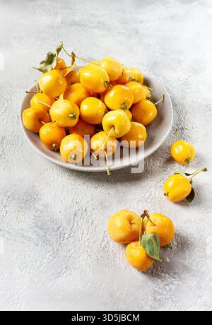 Mele piccole gialle, varietà cinese, su un piatto grigio, vista dall'alto, nessuna persona, Foto Stock