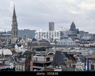 Belgio, Bruxelles, 31 dicembre 2024; paesaggio urbano di Bruxelles con municipio, ruota panoramica, tribunali e cielo coperto Foto Stock