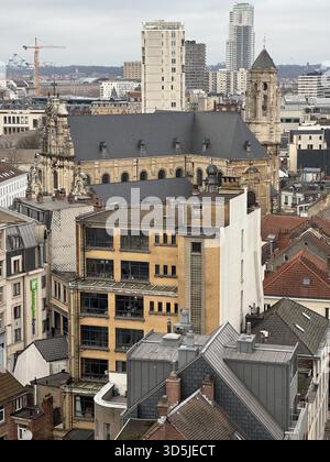 Belgio, Bruxelles, 31 dicembre 2024; la chiesa di saint Jean domina il paesaggio urbano di bruxelles, circondato da edifici moderni e gru da costruzione Foto Stock
