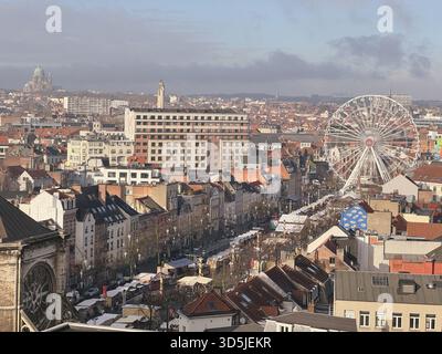 Belgio, Bruxelles, 31 dicembre 2024; veduta aerea di un vivace mercatino di natale a Bruxelles, belgio, con una ruota panoramica di spicco e il cit Foto Stock