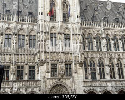 Grand Place a bruxelles, belgio, che mostra il municipio con la bandiera belga che sventolava orgogliosamente Foto Stock