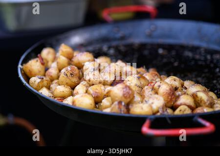 Primo piano di patate fritte appena cotte in una padella grande su un piano cottura a gas Foto Stock