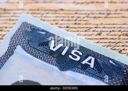 Vista ravvicinata di un visto per gli Stati Uniti stampigliato su una pagina del passaporto con sfondo della Costituzione degli Stati Uniti. Concetto di viaggio e immigrazione Foto Stock
