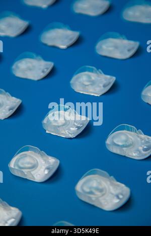 Vista dall'alto delle lenti a contatto per un giorno in una custodia protettiva monouso su uno sfondo blu su Foto Stock