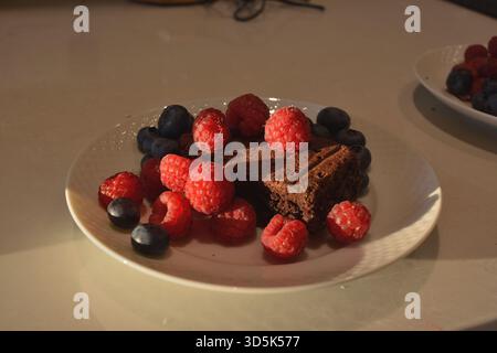 Ricco Brownie con lamponi e mirtilli freschi Foto Stock