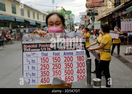 Bangkok, Thailandia - 22 luglio 2022: L'operaio della sala massaggi è visto nell'iconica via Khaosan. Foto Stock