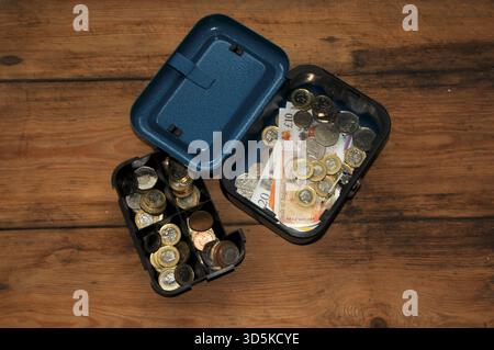 Cassa contenente monete e banconote in sterline britanniche Foto Stock