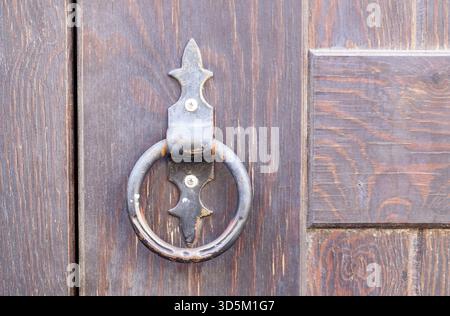 Maniglia in ferro vintage su una vecchia porta in legno naturale. Orientamento orizzontale, messa a fuoco selettiva Foto Stock