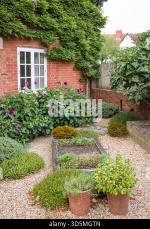 Piccolo giardino cottage in tarda estate con letti rialzati con letto in quercia e giardino duro. Giardini all'inglese, Regno Unito Foto Stock