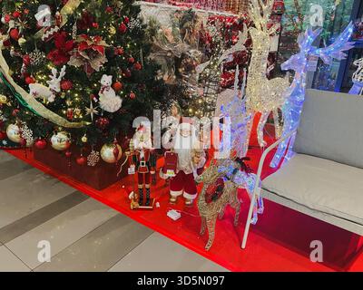 Balikpapan, Indonesia - 16 novembre 2025. Decorazioni natalizie, tra cui una figura di Babbo Natale, una statua del soldato Schiaccianoci e renne illuminate Foto Stock