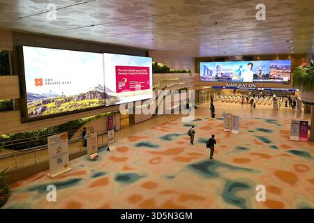 Vista della sala degli arrivi al Terminal 2 dell'Aeroporto Changi di Singapore con le corsie automatiche per l'immigrazione senza passaporto sulla destra Foto Stock