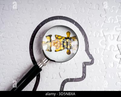Immagine concettuale che mostra il puzzle con la testa umana con lente di ingrandimento focalizza l'attenzione su ingranaggi colorati all'interno, simboleggia il processo mentale, la risoluzione dei problemi, psicolo Foto Stock
