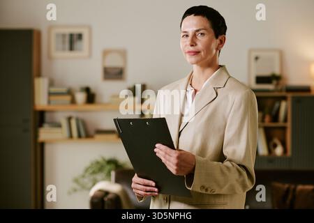 Ritratto di una donna caucasica di mezza età con appunti in ufficio di psicologia Foto Stock