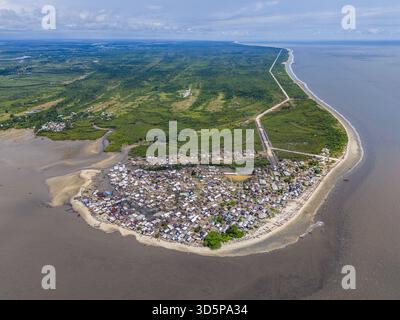 Vista aerea di un insediamento costiero densamente popolato circondato da acque fangose, accostate alla lussureggiante vegetazione verde più all'interno, Oyorokoto, fiumi Foto Stock