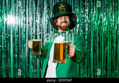 Leprechaun in tuta verde con tazze da birra alla festa di St Patricks sul set della festa Foto Stock