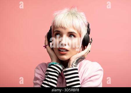 Una donna giovane e bella ama le sue canzoni preferite esprimendo il suo stile unico e la sua felicità. Foto Stock