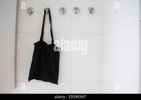 Elegante organiser ecocompatibile, borsa per il trasporto ecocompatibile dal design semplice su sfondo piastrellato Foto Stock