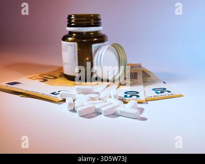 Costi farmaceutici: Pillole e euro - pillole da una bottiglia di medicinali con banconote da 50 euro, che simboleggiano l'alto costo dei farmaci e delle spese sanitarie Foto Stock