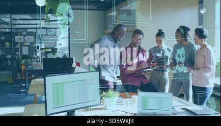 La collaborazione di cinque colleghi nel settore aziendale indossano un tablet per la visualizzazione in un ufficio open space, con monitor Foto Stock