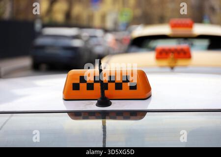 Cartello e antenna sul tetto giallo dell'auto sullo sfondo sfocato della strada, trasporto in città Foto Stock
