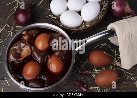 Colorare le uova di pollo per Pasqua con buccia di cipolla. Pasqua, domenica. Cibo sano. Chiave scura, rustica. Messa a fuoco selettiva Foto Stock